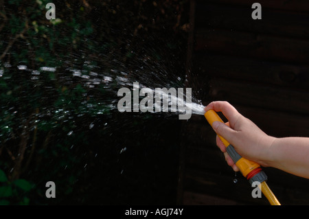 Hand mit einem Gartenschlauch. Stockfoto
