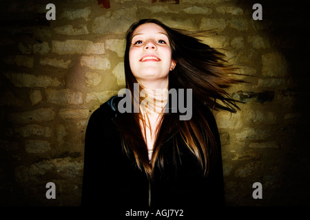 Porträt von Teenager-Mädchen gekleidet in schwarzes Oberteil, ihr Haar zur Seite schwingen. Stockfoto