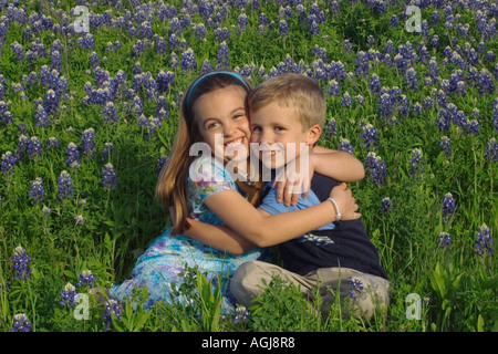 Bruder und Schwester zeigen ihre Zuneigung zueinander in den Kornblumen Stockfoto