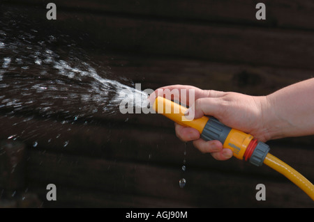 Hand mit einem Gartenschlauch. Stockfoto