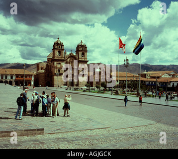 Touristen sind auf Cuzco Geschichte auf dem Hauptplatz der Stadt mit Kirche von la Campania im Hintergrund informiert. Stockfoto