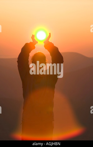 Eine Frau mit der untergehenden Sonne auf großen Torfgebieten, Lake District, Großbritannien Stockfoto