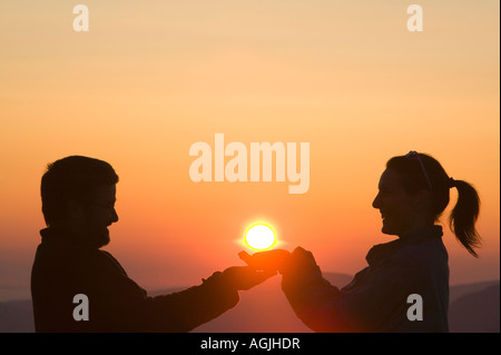 Ein paar halten die untergehende Sonne in den Lake District, Cumbria, UK Stockfoto