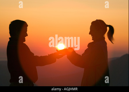 Ein paar halten die untergehende Sonne in den Lake District, Cumbria, UK Stockfoto