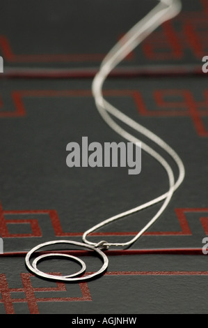 Halskette aus zwei handgefertigte Sterling Silber Ringe auf einer Box gelegt. Stockfoto