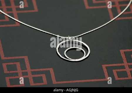 Halskette aus zwei handgefertigte Sterling Silber Ringe auf einer Box gelegt. Stockfoto