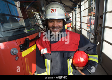 Feuerwehrmann mit einem Fußball Stockfoto