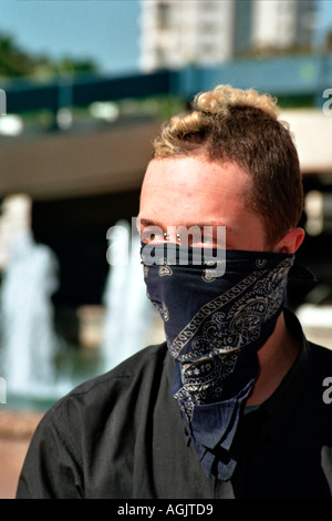 Ein junger Mann mit piercing verstecken sich vor den Kameras der Polizei während einer demonstration Stockfoto