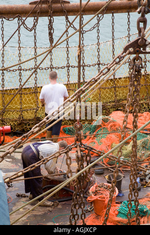 Routinemäßige Wartung und Sortieren der Netze an Bord eines Trawlers vor Anker in Newlyn Harbour Cornwall Stockfoto