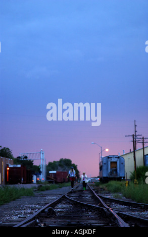 Zwei Mädchen im Teenageralter zu Fuß entlang der Gleise in der Abenddämmerung Santa Fe, New Mexico, USA, Nordamerika Stockfoto