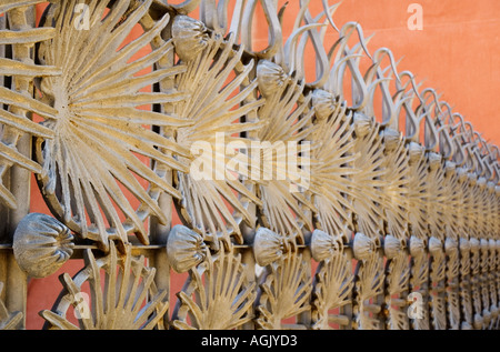 Detail der Gaudi s Schmiedearbeiten Tor vor Adobe-Wand im Parc Güell Barcelona Spanien Stockfoto