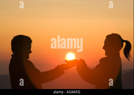 Ein paar hält der untergehenden Sonne auf großen Torfgebieten, Lake District, Großbritannien Stockfoto