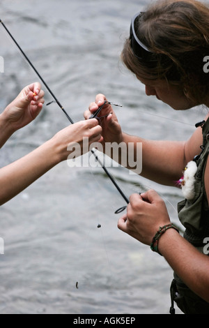 Junges Paar Fliegenfischen im Fluss Manistee Michigan MI ein Mann und eine Frau stehen im Wasser Bilder Bilder vertikales Format in den USA US Hi-res Stockfoto