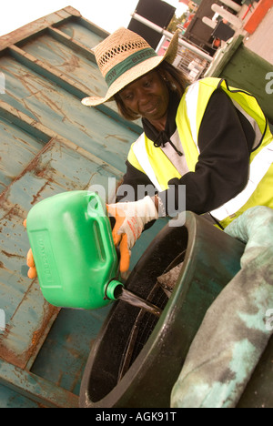 Mitarbeiter im Raum Schutzwasserwirtschaftlichen Recycling und Wiederverwendung von Zentrum, Feltham Middlesex, UK, Altöl entsorgen Motor. Stockfoto