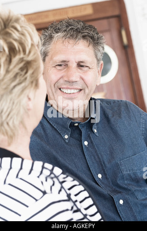 Ältere Mann im Gespräch mit einer reifen Frau und lächelt Stockfoto