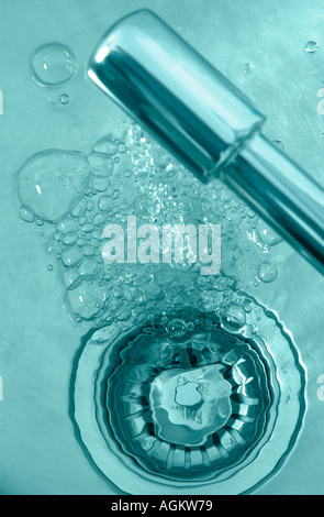 Wasserhahn mit Wasser hinunter den Stecker in eine Spüle gießen Stockfoto