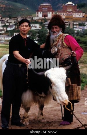 Chinesische Touristen posieren für ein Bild mit dem tibetischen Hirten Zhongdian County, Provinz Yunnan, China Stockfoto