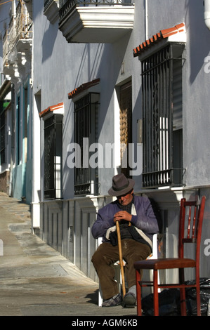 Alte Mann nimmt eine Siesta in der Straße in das Dorf Juzcar in der Nähe von Ronda Andalucia Spanien. Die Stadt wurde blau bemalt. Stockfoto