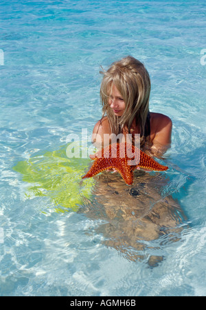 Frau im flachen Wasser mit Seestern Stockfoto