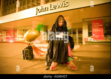 Start Harry Potter Buch 01:00 Oxford Street London junge Frau liest die ersten paar Seiten außerhalb John Lewis Department store Stockfoto