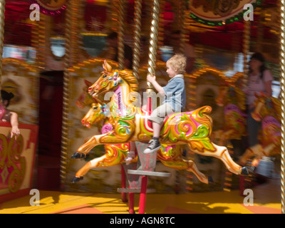 Junge, Reiten auf einem Rummelplatz Pferd auf einen Kreisverkehr bei Kirkleatham Redcar Cleveland UK 2006 Stockfoto