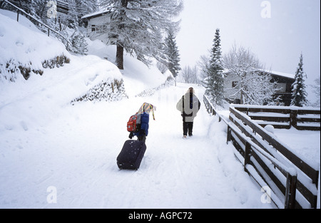 Schweiz, Mürren im Berner Oberland. Autofreie Skigebiet. Schleppen Gepäck zum Bahnhof auf hohe Straße © Brian Harris Stockfoto