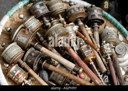 Korb mit Hand gehalten buddhistische Gebetsmühlen vor einem buddhistischen Tempel Geschäft in Swayambhu Stupa, Kathmandu, Nepal Stockfoto