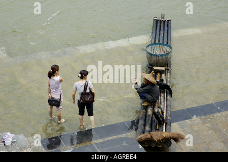 China-Guangxi Yangshuo zwei Frauen der Besuch des Dorfes und im Gespräch mit einem Kormoran Fischer am Li-Fluss Stockfoto