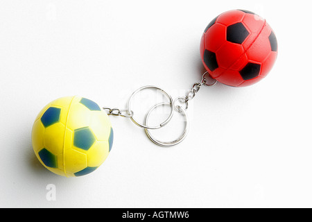 SSK79683 zwei Schlüsselanhänger gemacht der kleine gelbe und blaue rote und schwarze Kautschuk-Fußball Stockfoto