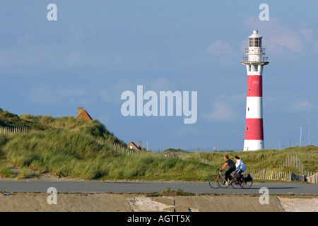 Menschen fahren Fahrräder hinter dem Leuchtturm von Nieuwpoort in Nieuwpoort in der Provinz Westflandern-Belgien Stockfoto