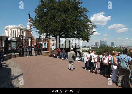 Menschen außerhalb der Eingang zum Greenwich Observatorium und Flamsteed House mit Isle of Dogs Canary Wharf Entwicklung über Greenwich Park London England Großbritannien Stockfoto