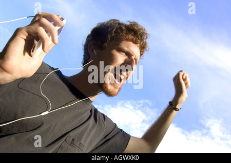 Junger Mann singen laut mit seinem Ipod MP3-player Stockfoto