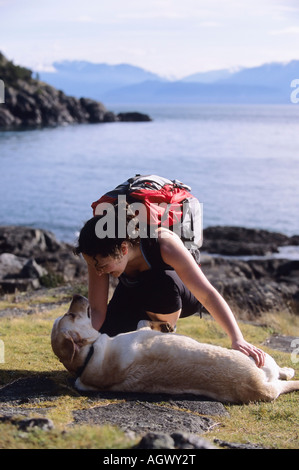 Eine Frau-Wanderer und ihr Hund im Osten Sooke Regional Park in der Nähe von Victoria BC Stockfoto