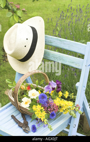 Traditionelle englische Sommer Garten Countryszene mit Schnittblumen in Trug auf Gartenbank Stockfoto