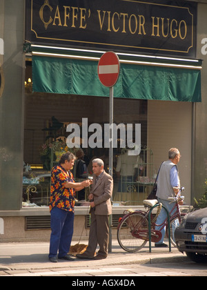 Zwei Männer und ein Hund Sonntagmorgen-Gespräch vor Cafe Victor Hugo auf Via Speronari in Mailand Italien Stockfoto