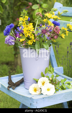 Traditionelle englische Sommer Garten Countryszene mit Schnittblumen im Eimer auf Gartenbank Stockfoto