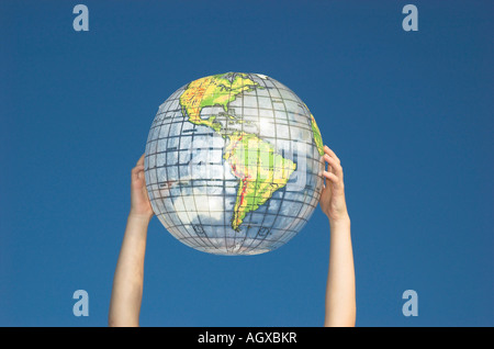 Junge Womans Hände halten Globus Stockfoto