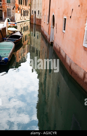 Reflexionen eines alten Gebäudes in einem engen Kanal in Venedig Stockfoto