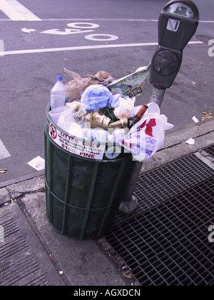 Mülltonne auf Stadtstraße mit Parkuhr überfüllt. Wurf, Geldstrafe von nur 100 $ auf Schild, Konzept der Abfälle, Plastik, Müll, urbane Stadtzentrum Stockfoto