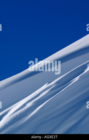 Wind geblasen Schneegrat mit blauem Himmel. Stockfoto