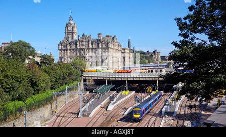 Ein Einblick in Waverley Station aus Westen mit einem Zug verlassen mit mehreren Edinburgh Tour Busse geparkt oben wartet auf Kunden Stockfoto