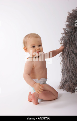 Baby mit grauem Schaffell Teppich Stockfoto