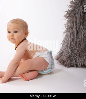 Baby mit grauem Schaffell Teppich Stockfoto