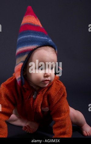 Baby in bunten Wollsachen Stockfoto