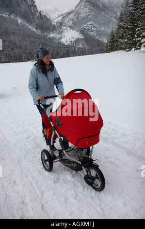 Frau mit Kinderwagen in Winterlandschaft Stockfoto