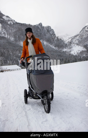 Frau mit Kinderwagen in Winterlandschaft Stockfoto