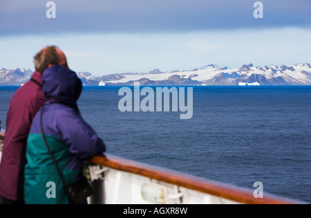 Paar in der Kleidung für kaltes Wetter Blick aufs Meer von der Schiene des Kreuzfahrtschiffes der südwestlichen Küste Grönlands mit Eisbergen Stockfoto