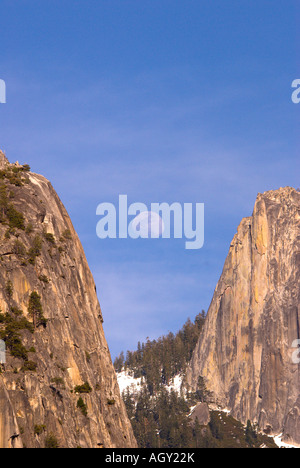 Yosemite-Nationalpark Vollmond über Bergen zwischen zwei Granitfelsen, die Hälfte Kuppel Felsen auf der rechten Seite Stockfoto