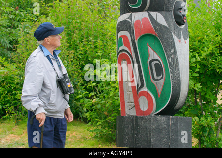 Senior männlichen Touristen Studium Handwerkskunst auf Namgis Nation Totempfahl in der Nähe von Umista Cultural Centre in Alert Bay, British Columbia Stockfoto