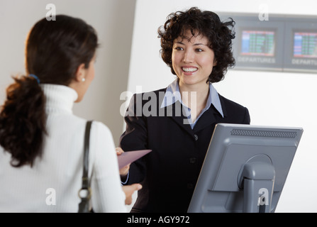 Airline-Mitarbeiter unterstützen Kunden am Ticketschalter Stockfoto